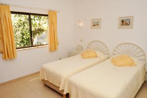 two beds in a room with a window at Vivenda Cinquenta e Sete in Poço Partido +19 photos