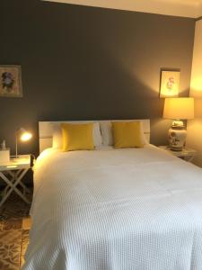 una camera da letto con un grande letto bianco con cuscini gialli di Chez Montiz a Montazels