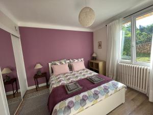 1 dormitorio con 1 cama grande y paredes moradas en SARLAT Centre ville - Appartement avec jardin et piscine, en Sarlat-la-Canéda