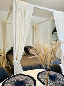 een kamer met een tafel met een bed op de achtergrond bij Lacacia - Suite de charme au calme avec Balnéo et Parking privé in Grasse