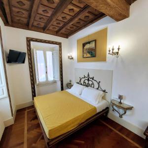 a bedroom with a bed with yellow sheets and a window at Arpinelli Relais in Rome