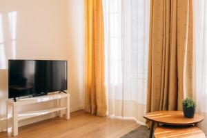 un salon avec une télévision, une table et une fenêtre dans l'établissement ORM Catedral & São Bento & Luiz Apartments, à Porto