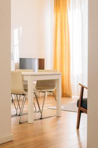 une table blanche et des chaises dans un salon dans l'établissement ORM Catedral & São Bento & Luiz Apartments, à Porto 118 autres photos