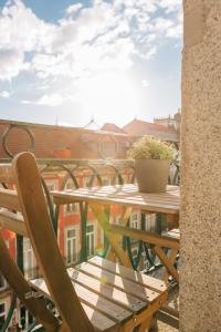 une table en bois avec une plante en pot sur un balcon dans l'établissement ORM Catedral & São Bento & Luiz Apartments, à Porto