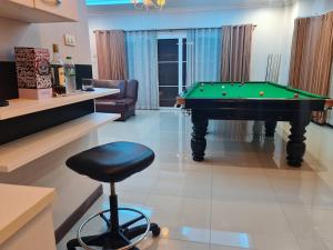 a living room with a pool table and a stool at การ์เด้นโฮม By คุณโทนี่ 