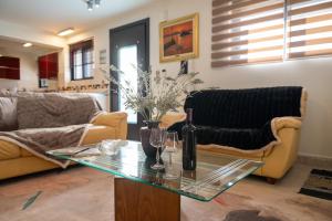 a living room with a couch and a table with wine glasses at Lobelia Nafplio Apartments in Nafplio