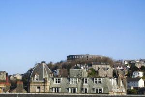 a city with a castle on top of a hill at Argyll Apartments - High Street, Oban in Oban