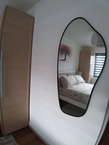 a mirror reflecting a bedroom with a bed in a room at The Annexe Cheadle Hulme in Cheadle Hulme