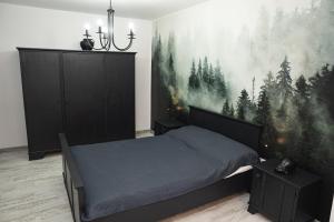 1 dormitorio con 1 cama y una pintura en la pared en MJ Apartment, en Lupeni