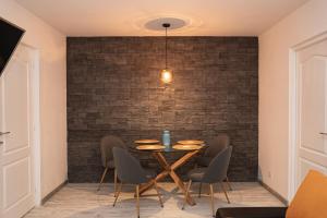 a dining room with a brick wall and a table and chairs at MJ Apartment in Lupeni