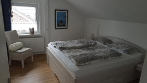 a bedroom with a bed and a chair and a window at Haus Marienfried in Rettenberg