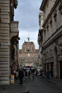 un grupo de personas caminando por una calle entre edificios en Residenze Romanae - Sangallo Rooms, en Roma