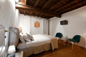 - une chambre avec un lit, une table et des chaises dans l'établissement Residenze Romanae - Vicolo 22, à Rome
