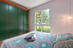 ein Schlafzimmer mit einem Bett und einem Fenster in der Unterkunft Rosa Edifício Giovani Pizetta in Gramado