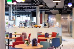 a restaurant with tables and chairs and a counter at ibis Styles Bern City in Bern