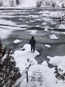 una persona che cammina attraverso un fiume nella neve di Yablunevyi Tsvit a Jaremče
