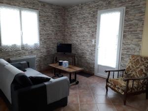 a living room with a couch and a chair at Maison 2 chambres proche plage avec jardin, animaux et Wi-Fi à L'Aiguillon-sur-Mer - FR-1-476-23 in LʼAiguillon-sur-Mer