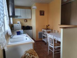 a kitchen with a sink and a table and a kitchen with a tableablish at Maison 2 chambres proche plage avec jardin, animaux et Wi-Fi à L'Aiguillon-sur-Mer - FR-1-476-23 in LʼAiguillon-sur-Mer +4 photos