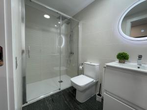 een badkamer met een douche, een toilet en een wastafel bij AP Carretería Deluxe in Cuenca