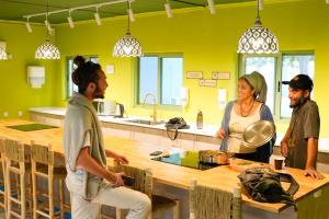 un groupe de personnes debout dans une cuisine dans l'établissement Selina Mantur Almog Dead Sea, à Almog