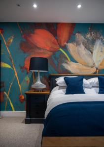 a bedroom with a painting of flowers on the wall at The Flyford in Worcester