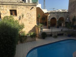 a swimming pool in front of a building at studio apartment with pool in house of character. in Birkirkara