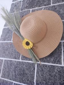 um chapéu de palha com uma flor amarela no chão em Da Noi em Vico del Gargano