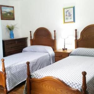 a bedroom with two twin beds and a dresser at Casa Rural Barangua en el Pirineo Aragonés in Santa Cruz de la Serós