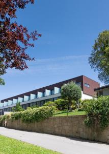 a building with a stone wall in front of a building at Prazer da Natureza Resort & Spa in Caminha