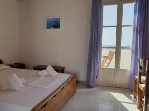 a bedroom with a bed and a view of the ocean at Silver Rocks Hotel in Chrissi Akti