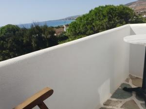 a chair on a balcony with a view of the ocean at Silver Rocks Hotel in Chrissi Akti