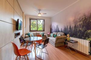 a living room with a couch and a table at Rosa Edifício KnorrVille in Gramado
