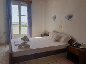 a bedroom with a bed and a window with a view at Silver Rocks Hotel in Chrissi Akti