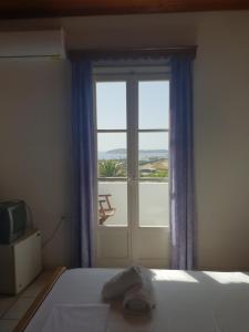 a bedroom with a bed and a window with a view at Silver Rocks Hotel in Chrissi Akti