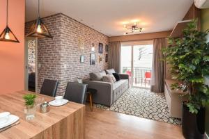 un salon avec un canapé et une table dans l'établissement Rosa Edifício Centro One, à Gramado