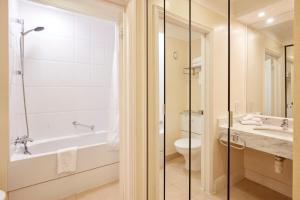 a bathroom with a tub and a toilet and a sink at Coldra Court Hotel by Celtic Manor in Newport