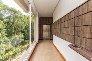 un corridoio di una casa con una grande finestra di Rosa Edifício Parque da Vinícola a Gramado