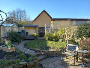 un jardín con una silla y una mesa en Laurel cottage Melplash, en Netherbury