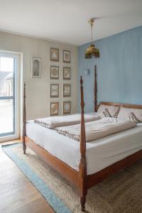 una camera da letto con un grande letto con lenzuola bianche di Alte Flachsfarm a Cottbus