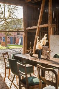 un tavolo e sedie in legno in un fienile di Alte Flachsfarm a Cottbus