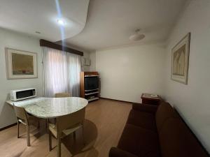 uma sala de estar com uma mesa e um sofá em Locking's Funcinários 5 em Belo Horizonte