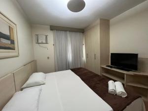 um quarto com uma cama grande e uma televisão de ecrã plano em Locking's Funcinários 5 em Belo Horizonte