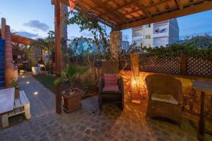 eine Terrasse mit zwei Stühlen unter einer Pergola in der Unterkunft Sakaroule B&B in Santa Maria