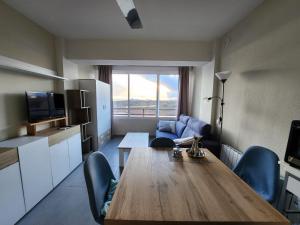 sala de estar con mesa de madera y cocina en Apartamentos Tramuntana42, en Roses