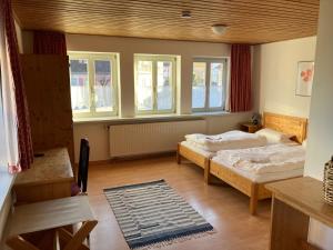 a bedroom with two beds and windows and a rug at Hotel & Landgasthof Zur Sonne 