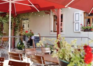 une terrasse avec une table, des chaises et un parasol dans l'établissement Hotel & Landgasthof Zur Sonne, 