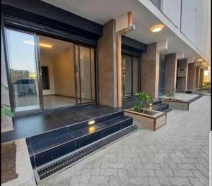 ein Haus mit Glastüren und einem Innenhof mit Topfpflanzen in der Unterkunft DG's Suites in Nairobi