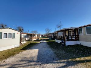 a row of mobile homes on a dirt road at Campeggio Don Bosco in Lido di Jesolo