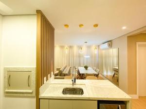 a kitchen and living room with a sink and a table at Rosa Edifício Vivere Canela in Canela +49 photos