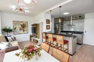 a kitchen and living room with a table and chairs at Rosa Edifício Vivere Canela in Canela